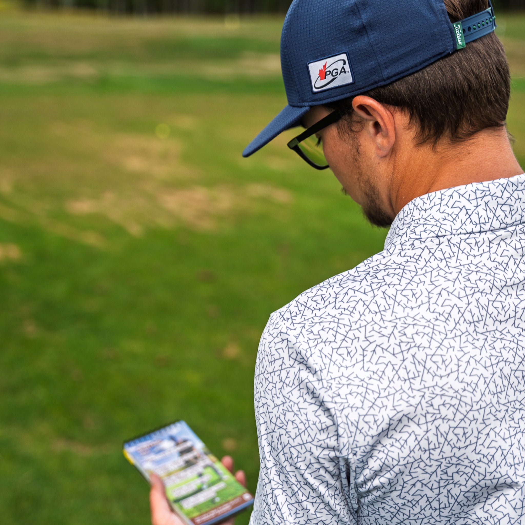 Golfer reading Golf Cheat Sheets on the course
